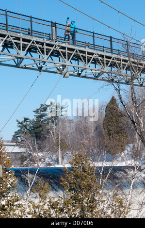 Padre e figlia in inverno stare in cima al ponte di Montmorency cade in Québec in Canada con il fiume e il ghiaccio e la neve qui di seguito. Foto Stock