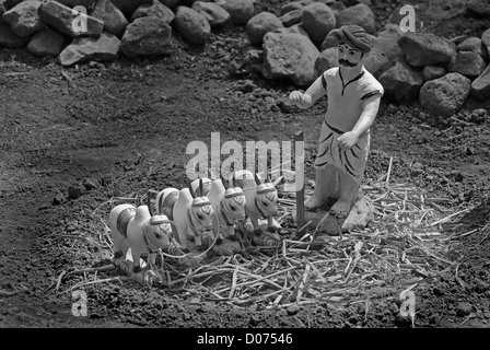 Statua in miniatura di un agricoltore che lavorano in un campo la trebbiatura del modo tradizionale con allevamento di bestiame Foto Stock