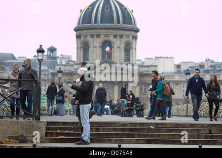 Institut de France dome . i turisti guardano una mappa prima di attraversare il Pont des Arts , Parigi Foto Stock