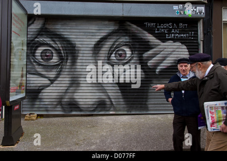 Due uomini davanti a dei graffiti su un rullo porta su una edicola 'che assomiglia ad un elefante!!" North Street Bedminster Bristol Foto Stock