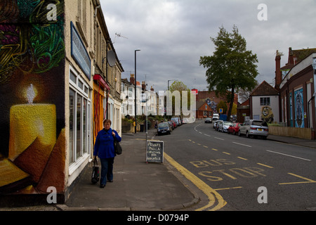 North Street, Bedminster, Bristol, che mostra tre a quattro pezzi di graffiti - una candela, un leone, stilizzazione di una donna e una ragazza Foto Stock