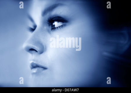 Giovane elegante signora faccia chiudere verso l'alto. Le tonalità blu. Foto Stock