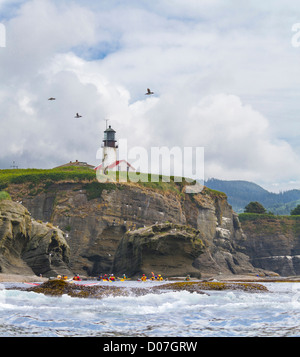 Stati Uniti d'America. Nello stato di Washington. Sea Kayakers racchetta sotto il faro di Isola di Tatoosh vicino a Capo le lusinghe. Composito Digitale. Foto Stock