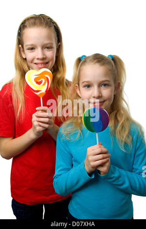 Due giovani ragazze bionda con lollipop su sfondo bianco Foto Stock