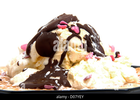 Deliziosi dessert con waffle e gelati su piastra nera su sfondo bianco Foto Stock