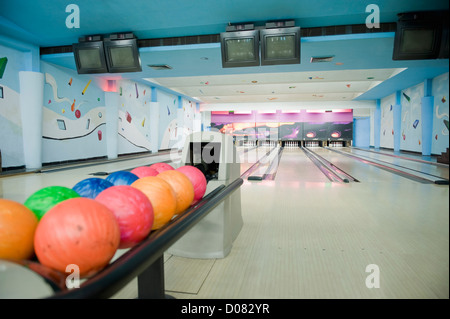 Palle da bowling disposti su un rack in un impianto da bowling Foto Stock