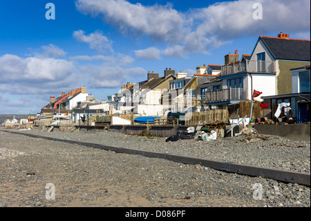 Colorato villaggio costiero case Borth Galles centrale il cui giardini torna sulla spiaggia, mare difese, linee di lavaggio, driftwood Foto Stock