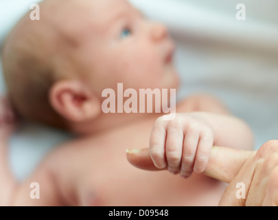 Neonato sdraiato su coltre bianca Foto Stock