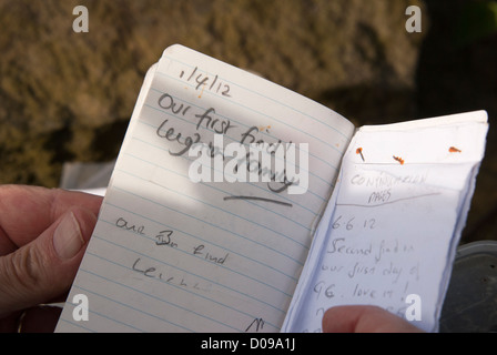 Il riempimento del registro di geocache dopo aver trovato la cache. Geocaching, Sheffield South Yorkshire, Inghilterra. Foto Stock