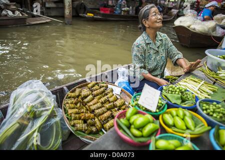 Nov. 17, 2012 - Bangkok, Thailandia - Una donna vende produrre in un mercato galleggiante in Thonburi sezione di Bangkok. Mercati galleggianti sono comuni in parti della Tailandia con un sacco di canali. Bangkok utilizzato per essere noto come ''Venezia dell'Est'' a causa del numero di vie navigabili il Criss Crossed la città. Ora la maggior parte delle vie navigabili sono state riempite in ma le barche e navi continuano a svolgere un ruolo importante nella vita quotidiana a Bangkok. Migliaia di persone si reca al lavoro ogni giorno sul Fiume Chao Phraya Express barche e barche veloci che tela Khlong Saen Saeb o utilizzare imbarcazioni per aggirare sui canali in Thonburi sid Foto Stock