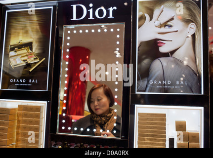 Turisti cinesi cercando Dior di prodotti in un centro commerciale per lo shopping a Parigi, Francia Foto Stock