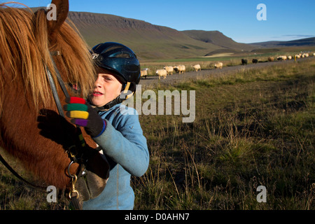 Bambino islandese il suo cavallo grande Round-up degli allevamenti ovini (RETTIR in islandese) islandese di tradizione che consiste di portare indietro le pecore Foto Stock