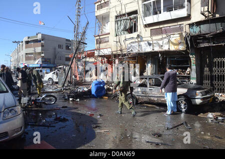 Il personale addetto alla sicurezza e le persone si radunano presso il sito dopo la bomba che è stata piantata su un ciclo di Shahbaz città di Quetta Mercoledì, Novembre 21, 2012. Almeno sette persone uccise tra cui tre FC personale e più di sedici feriti in esplosione, personale di FC sono stati presi di mira in attacco. Foto Stock