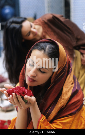 Giovane donna marocchina annusare i petali di rosa la vita quotidiana in un riad nella medina di Marrakech marocco AFRICA Foto Stock