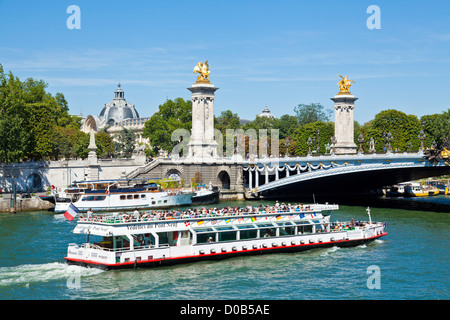 Un Bateaux Mouches tour in barca piena di turisti sul fiume Senna passando sotto il Pont Alexandre III Parigi Francia EU Europe Foto Stock