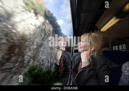 Una donna del passeggero sulla la locomotiva a vapore di bolina 'Giacobita' treno su un viaggio da Fort William a Mallaig nelle Highlands Scozzesi. Foto Stock