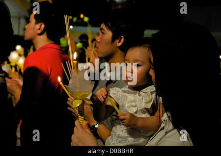 Famiglia Thai prega w/ candele & incensi, Wat Saket Phu Khao Thong (Golden Mountain), Bangkok, Thailandia. Credito: Kraig Lieb Foto Stock