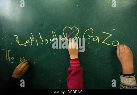 Nov. 21, 2012 - Gaza City, nella Striscia di Gaza - bambini palestinesi scrivere su una lavagna dove le famiglie sfollate sono stare dopo aver evacuato le loro case in precedenza questa settimana a rifugiarsi presso le Nazioni Unite (ONU) Scuola di Gaza City mercoledì. (Credito Immagine: © Majdi Fathi/immagini APA/ZUMAPRESS.com) Foto Stock