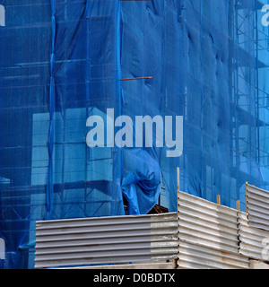 Edificio sotto i detriti netting al sito in costruzione. Recinzione in alluminio e impalcatura. Foto Stock