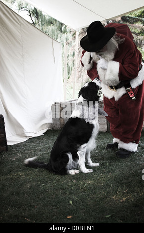 Babbo Natale che entrano in una tenda occidentale con i regali di Natale un acquietamento watch dog Foto Stock