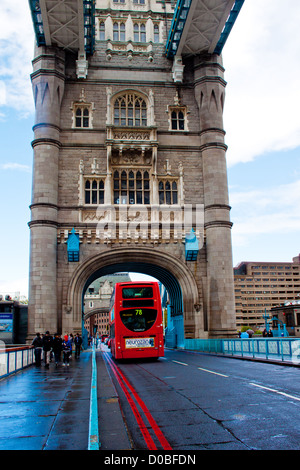 Un bus rosso passa attraverso un arco su Tower Bridge, Londra Foto Stock