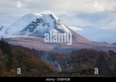 Crepuscolo sopra il vertice di Baosbheinn con fuochi andando in Crofts che sono immerso nei boschi. Foto Stock