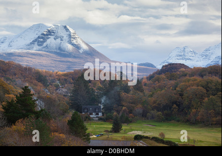 Crepuscolo sopra il vertice di Baosbheinn con fuochi andando in Crofts che sono immerso nei boschi. Foto Stock