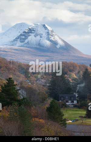 Crepuscolo sopra il vertice di Baosbheinn con fuochi andando in Crofts che sono immerso nei boschi. Foto Stock