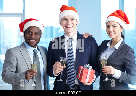 Tre partner commerciali in Santa tenendo i tappi di champagne e vi auguriamo buon Natale Foto Stock