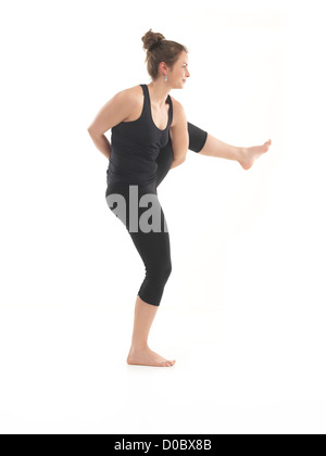 Dimostrazione di equilibrio lo yoga pone dalla giovane donna vestita di nero su sfondo bianco Foto Stock