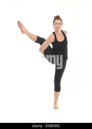 Giovane donna che mostra difficile posture yoga, vista frontale, vestito di nero su sfondo bianco Foto Stock