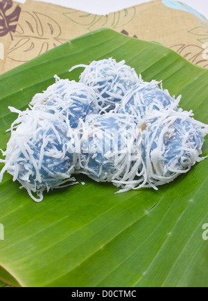 Tradizione Thai dessert con banana stuff e fette di cocco topping sulla foglia di banano. Foto Stock