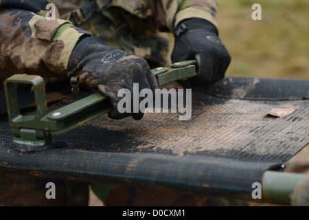 Un U.S. Air Force airman assegnato alla 606th Air Control Squadron, blocca la trave di supporto su una cucciolata prima di utilizzare durante la Combat Readiness training nov. 15, 2012. La combat readiness assicurata la formazione che i partecipanti erano in grado di eseguire medical e s Foto Stock