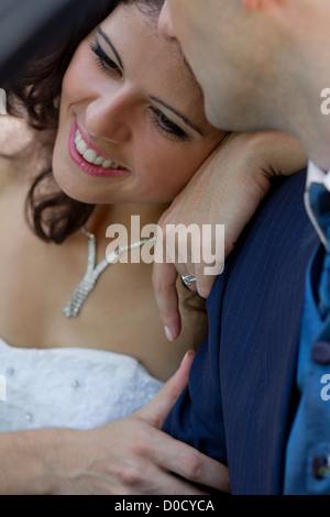 Felice giovane sposa appoggiata sulla sua spalla forte Foto Stock