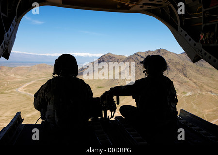Army Air equipaggio profilarsi nel retro di un CH-47 Chinook volando verso Kabul Foto Stock