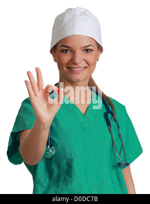 Giovane donna medico dando alright segno, isolata contro uno sfondo bianco Foto Stock