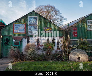 Lion Boathouse su Eel Pie Island, Twickenham, Greater london - Un edificio verde in ferro ondulato decorato con vecchi cartelli pubblicitari Foto Stock