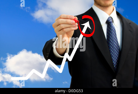Imprenditore volteggiare una freccia ascendente su un grafico (che rappresenta la crescita) Foto Stock