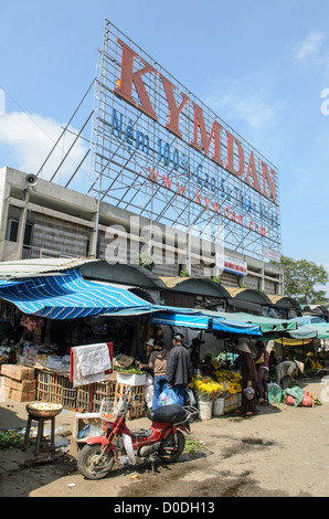 Cho Dong Ba Market insegna pubblicitaria Hue Vietnam // HUE, Vietnam — un cartello pubblicitario a Cho Dong Ba, il principale mercato cittadino di Hue. Cho Dong Ba funge da mercato centrale di Hue, situato lungo le rive del fiume Perfume nell'ex capitale imperiale. Il mercato è situato nel cuore di Hue, una città patrimonio dell'umanità dell'UNESCO, conosciuta per il suo significato storico come sede della dinastia Nguyen. Il fiume Perfume scorre attraverso il centro di Hue, dividendo la città e collegando vari quartieri. Hue si trova nel Vietnam centrale, nella provincia di Thua Thien-Hue. Foto Stock