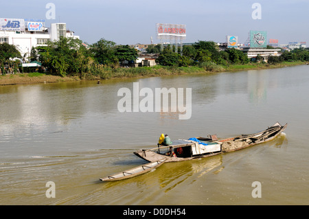Sampan di legno che trasporta terreno dragato Fiume Profumo Hue Vietnam | HUE, Vietnam — Un sampan di legno che trasporta terreno dragato naviga sul fiume Profumo. Lo scafo poco profondo e a fondo piatto della nave è progettato per trasportare pesanti materiali da costruzione attraverso le rive fangose in movimento senza incagliarsi. Sabbia e sedimenti estratti direttamente dal letto del fiume Profumo servono come materie prime primarie per l'industria edilizia urbana del Vietnam centrale. Foto Stock
