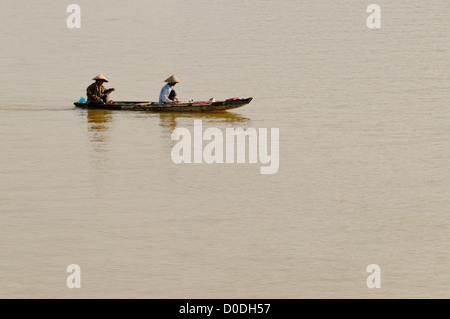 Sampan Boat Perfume River Hue Vietnam // HUE, Vietnam - due persone in un tradizionale sampan di legno scivolano sulle lisce acque marroni del fiume Perfume a Hue, nel Vietnam centrale. Foto Stock