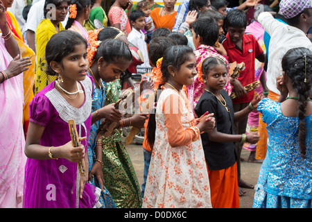 Giovani indiani ragazze con i cembali a mano a una festa per le strade di Puttaparthi. Andhra Pradesh, India Foto Stock