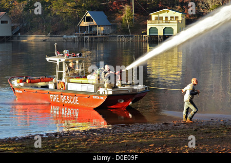 TIGER, GA, Stati Uniti d'America - nov. 9: un gruppo di uomini in un combattimento fireboat un eveining casa di fuoco. Il 9 novembre 2012, sul lago di Burton. Foto Stock