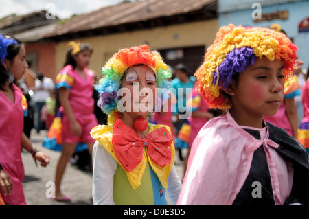 Guatemala Independence Day Parade Antigua Guatemala // ANTIGUA GUATEMALA, Guatemala — durante la mattina del giorno prima del Guatemala Independence Day (che si celebra il 15 settembre), centinaia di scolari provenienti da Antigua e dai villaggi circostanti marciano in una sfilata di gruppi scolastici ad Antigua, alcuni in costume e altri nelle loro uniformi scolastiche. La sfilata include anche bande di marciare scolastiche e cheerleader. La processione inizia al Parque Central e si snoda oltre la chiesa gialla di la Merced e lo stadio municipale. Foto Stock