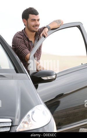 Uomo in piedi accanto a AUTO, Ritratto Foto Stock