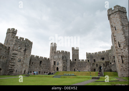 CAERNARFON, Galles — bastioni visti dal cortile interno del castello di Caernarfon nel Galles nord-occidentale. Un castello originariamente sorgeva sul sito risalente alla fine dell'XI secolo, ma alla fine del XIII secolo re Edoardo i commissionò una nuova struttura che si erge fino ad oggi. Ha torri caratteristiche ed è uno dei castelli meglio conservati della serie commissionata da Edoardo I. Foto Stock