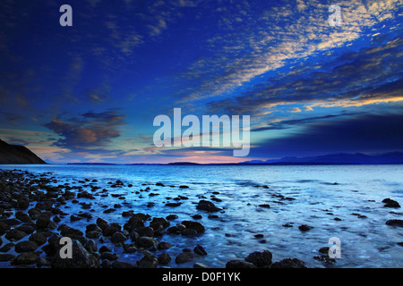 Tramonto sul post-incandescenza rocky Ebey's Beach, a Fort Ebey parco dello stato di Washington, lungo Puget Sound. Foto Stock