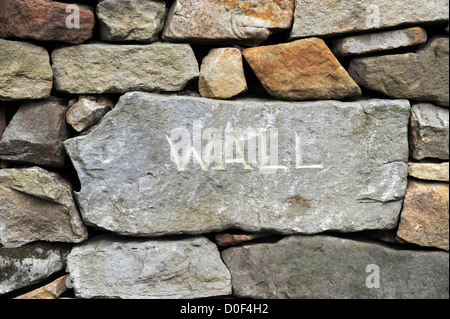 Muro di pietra costruire nel North York Moors con la pietra nome wallers Adrian scavata nella parete. Foto Stock
