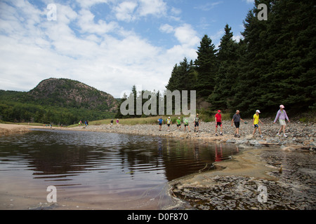 Gli escursionisti indossando variopinti outdoor gear a piedi attorno a un lago nel parco nazionale di Acadia vicino a Bar Harbor Maine, Stati Uniti d'America Foto Stock