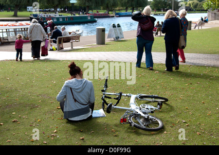 Ciclista seduta vicino al fiume Avon, Stratford-upon-Avon, Regno Unito Foto Stock